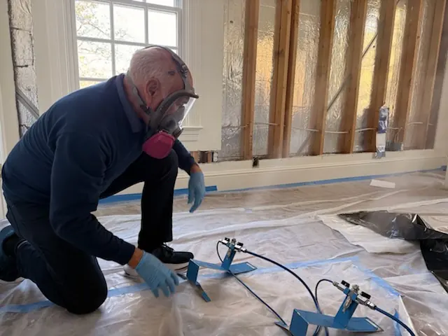 A restoration technician setting drying equipment in an Orlando home stripped to the studs
